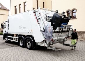 Weißes Müllfahrzeug leert Mülleimer